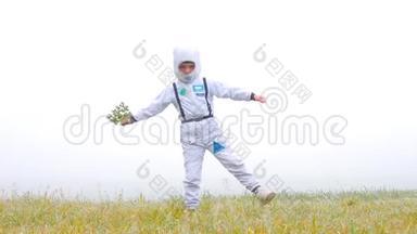 一个穿着宇航员服装的男孩手里拿着一株植物。